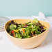 A GET Osslo Dijon melamine bowl filled with salad on a table.