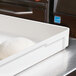 A white MFG Tray dough proofing box with white dough inside on a counter.
