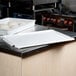 A white rectangular MFG Tray fiberglass dough proofing box lid on a counter.