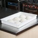 A white MFG Tray fiberglass proofing box with six balls of pizza dough in it.