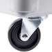 A close-up of a white plastic wheel on a gray fiberglass dolly.