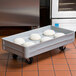 A gray MFG Tray fiberglass dough proofing box dolly with trays of dough on it.