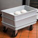 A gray fiberglass MFG Tray dough proofing box dolly with dough inside.