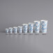 A row of Choice white paper cold cups with blue lines in different sizes.