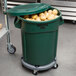 A green Rubbermaid BRUTE trash can filled with potatoes.