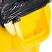 A yellow Rubbermaid BRUTE trash can with a black bag over it.