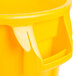 A yellow Rubbermaid BRUTE trash can with lid and dolly handles.