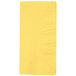 A yellow paper napkin with a square pattern.