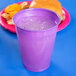 A Creative Converting amethyst purple plastic cup with ice and a burger on a blue surface.