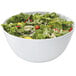 A white GET Diamond White melamine bowl filled with salad including lettuce, tomatoes, and onions.