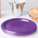 A stack of Creative Converting amethyst purple paper plates.