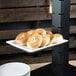 A Libbey rectangular porcelain plate with bagels on it.