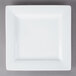 A white square Libbey porcelain plate with a white rim on a gray surface.