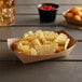 A #100 Natural Eco-Kraft paper food tray with potato chips and dip on a table.