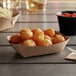 A natural Eco-Kraft paper food tray filled with fried food on a table.