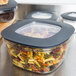 A Rubbermaid clear plastic food storage container filled with pasta.