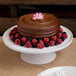 A chocolate cake with Ghirardelli Sweet Ground Chocolate & Cocoa Powder and berries on top.