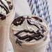 A glass of chocolate milkshake with Ghirardelli chocolate sauce and whipped cream.