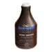 A brown bottle of Ghirardelli Sweet Ground Chocolate & Cocoa Flavoring Sauce with a label.