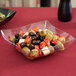A close up of a Fineline clear plastic serving bowl with olives and peppers.
