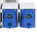 A close-up of a couple of blue and white Dema V-Line OPL laundry chemical dispenser pump system electrical boxes.