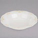 A Fineline Heritage white plastic bowl with gold trim.