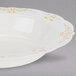 A Fineline white plastic bowl with gold trim.