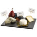 A Tablecraft black melamine display tray with blue cheese, grapes, and a cheese board.