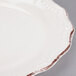 A white stoneware salad plate with brown rim.