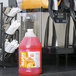 A jug of Carnival King Orange Slushy Concentrate on a counter.