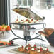 Vollrath universal electric chafer heater keeping food warm on a buffet table outdoors.