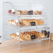 An extra large bakery display case with bagels and pastries inside.