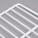 A close up of a white coated wire grid shelf.