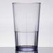 A clear Cambro Lido plastic tumbler filled with water on a table.