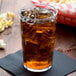 A Cambro clear plastic tumbler filled with ice tea and ice cubes.