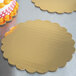 A gold laminated corrugated cake circle with a cake on top.