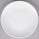 A white 10 Strawberry Street Wazee Matte stoneware salad plate on a gray surface.