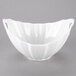 A white porcelain boat bowl with wave texture and handles.