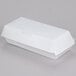 A 7" x 3" x 2 5/8" white paper sandwich clamshell container on a gray surface.