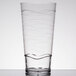 A clear plastic tumbler with wavy lines.