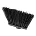 A black broom head with long black bristles.
