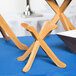 Tablecraft RFTT3BAM 3-piece fold-away bamboo riser set on a table with wooden bowls on top.