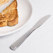 A piece of toast on a plate with a Libbey Fairfield bread and butter knife.