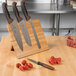 A Mercer Culinary Millennia Colors® knife set on a bamboo magnetic board.