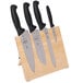 A Mercer Culinary Millennia® knife set with black handles on a wooden magnetic board.
