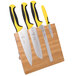A Mercer Culinary Millennia Colors® yellow and black knife set on a bamboo magnetic board.