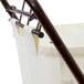 A white fabric bag hanging from a metal rod inside a bronze rectangular laundry hamper.
