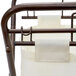 An antique bronze rectangular metal laundry hamper with a white fabric bag on a metal frame.