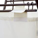 A white fabric bag hanging from a metal bar.