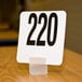 An American Metalcraft frosted white acrylic cube card holder with a black number 200 on it.